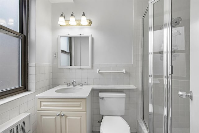 bathroom featuring vanity, toilet, tile walls, and a stall shower
