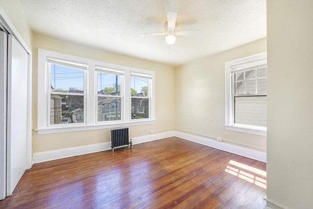 3399 Ely Ave, Bronx, NY 10469 - unfurnished room with hardwood / wood-style floors, baseboards, ceiling fan, radiator heating unit, and a textured ceiling
