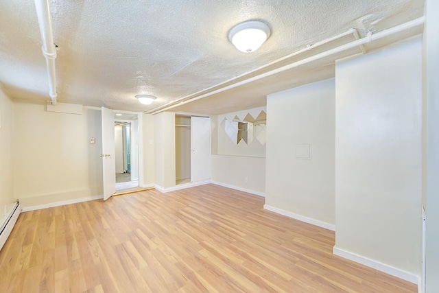 3399 Ely Ave, Bronx, NY 10469 - finished below grade area with baseboards, light wood finished floors, and a textured ceiling
