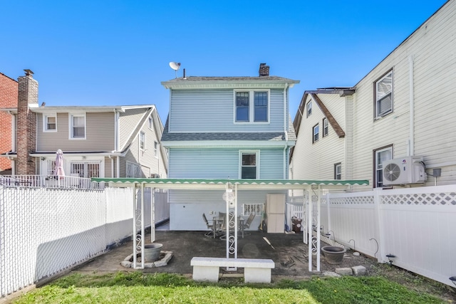 3399 Ely Ave, Bronx, NY 10469 - back of property featuring a fenced backyard, roof with shingles, a chimney, a patio area, and ac unit