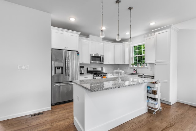 214 Phillips St, Middletown, NY 10940 - kitchen with appliances with stainless steel finishes, a center island, light stone countertops, white cabinets, and dark wood-style floors