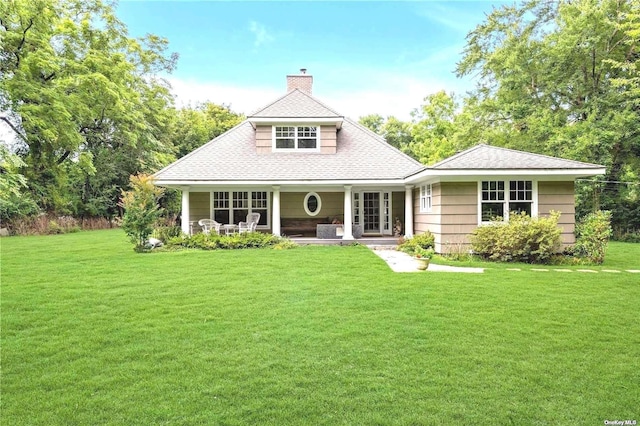 1 Breeze Hill Rd, Northport, NY 11768 - view of front facade with a porch, a chimney, roof with shingles, and a front lawn