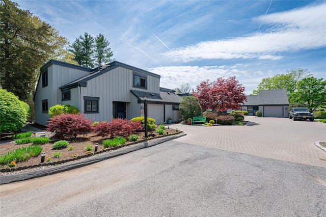 view of front facade featuring an attached garage, board and batten siding, and aphalt driveway