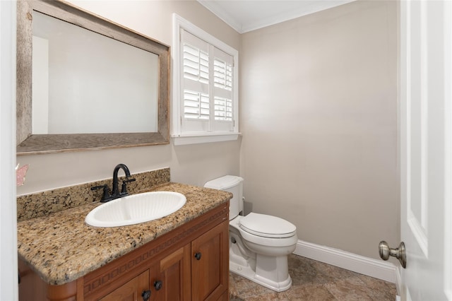 bathroom featuring vanity, ornamental molding, baseboards, and toilet