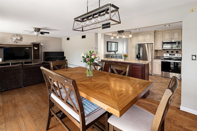 dining room with ceiling fan and wood finished floors