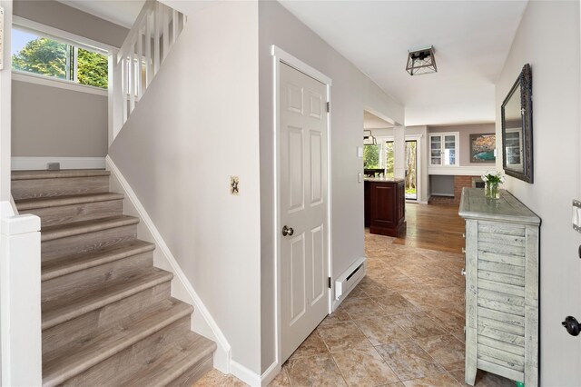 stairway featuring baseboards and a baseboard radiator
