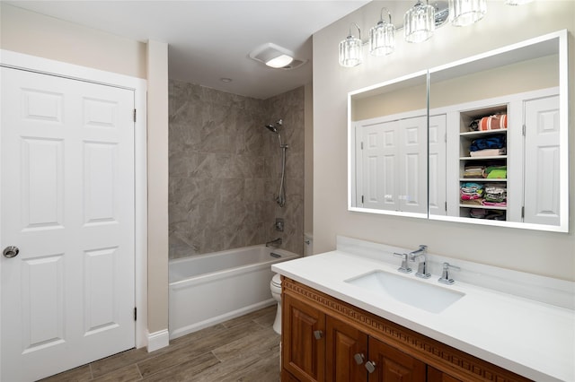 bathroom featuring wood finished floors, vanity, a closet, toilet, and shower / bathtub combination