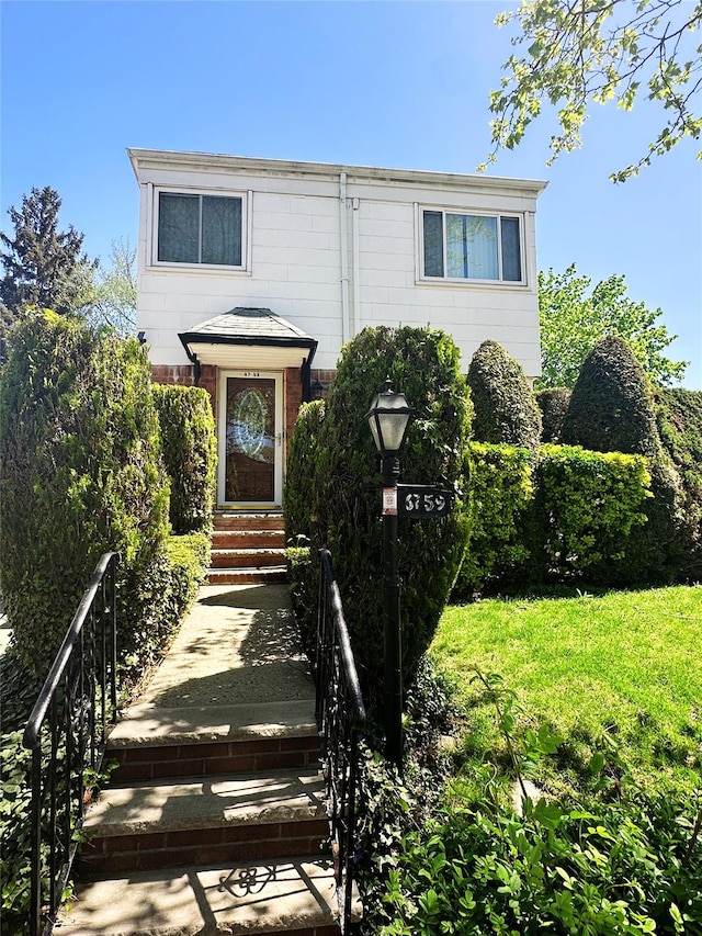 view of front of home featuring brick siding and a front yard