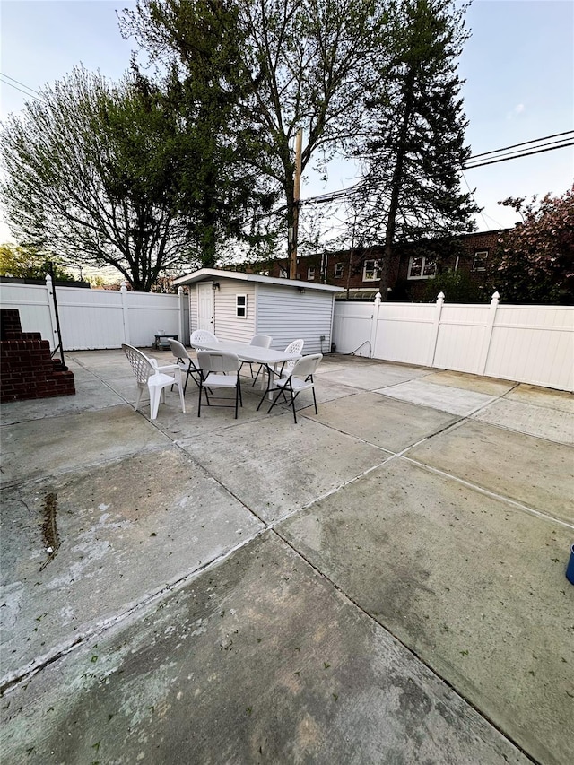 view of patio / terrace featuring an outdoor structure, fence, and outdoor dining space