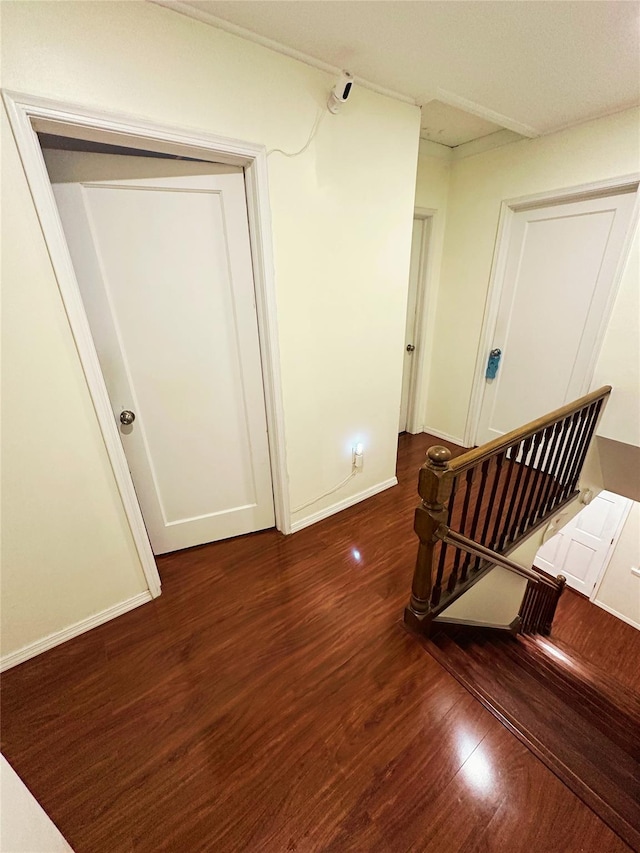 corridor featuring baseboards and wood finished floors
