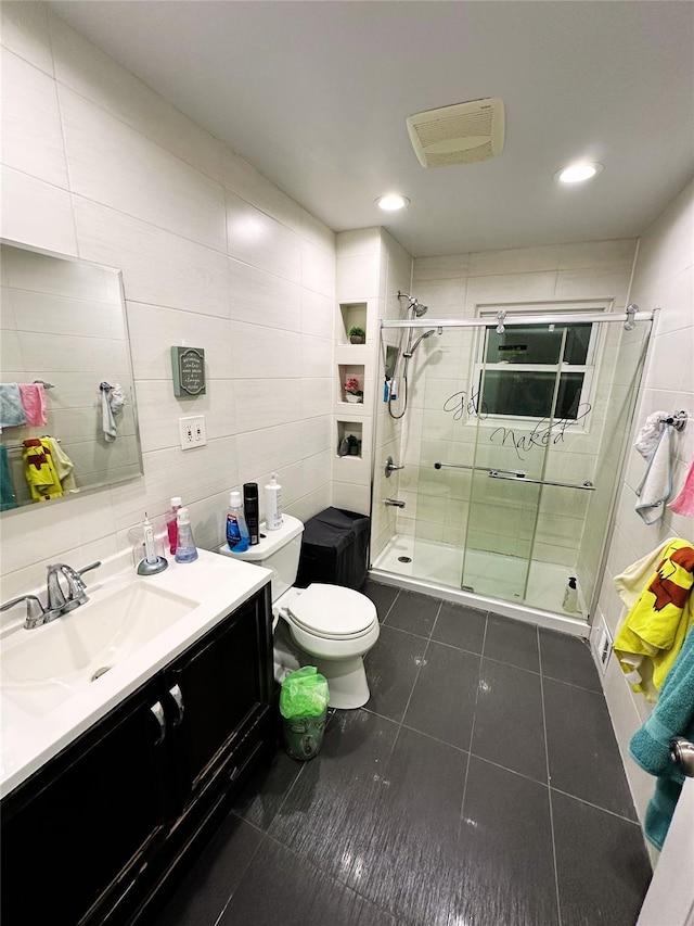 full bathroom with tile patterned flooring, a shower stall, toilet, and tile walls