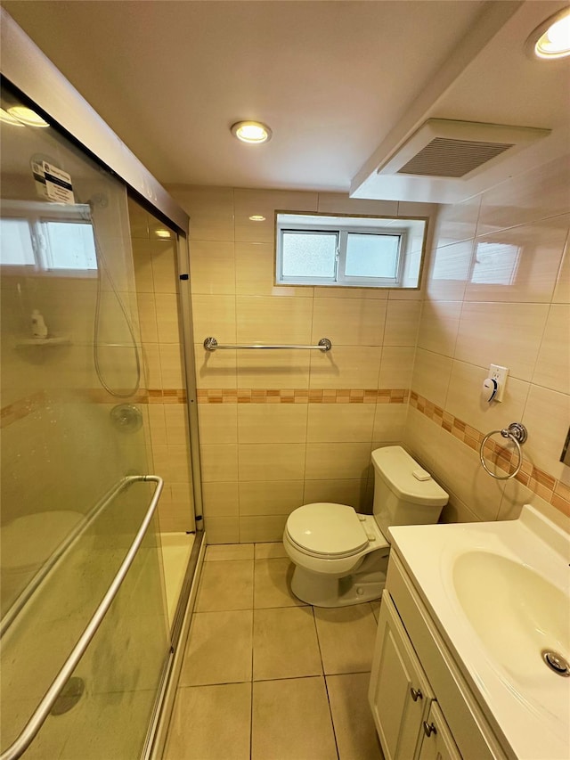 full bath featuring vanity, toilet, tile patterned floors, tile walls, and a shower stall