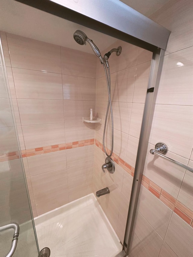 full bath featuring tile patterned flooring and tiled shower