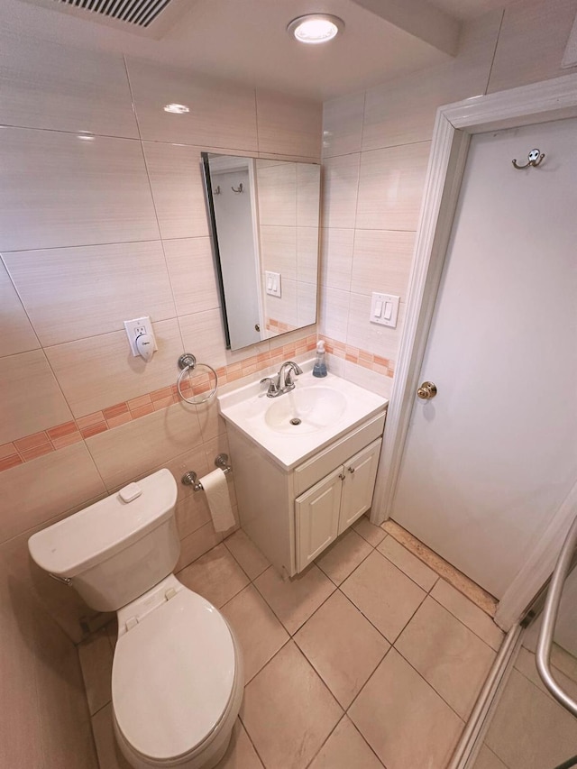 bathroom featuring vanity, decorative backsplash, toilet, tile walls, and tile patterned floors