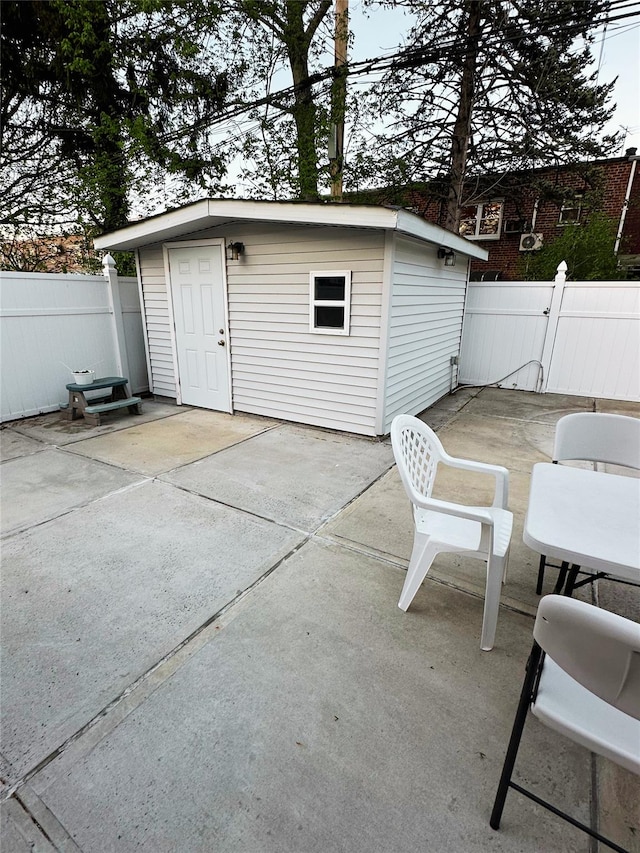 view of patio featuring an outdoor structure and fence