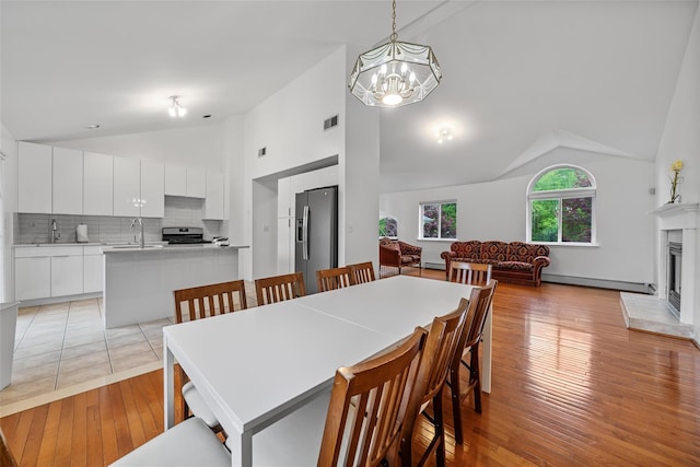 4 Sequoia Trl, Highland Mills, NY 10930 - dining room featuring visible vents, a fireplace with raised hearth, a baseboard radiator, an inviting chandelier, and light wood-style floors