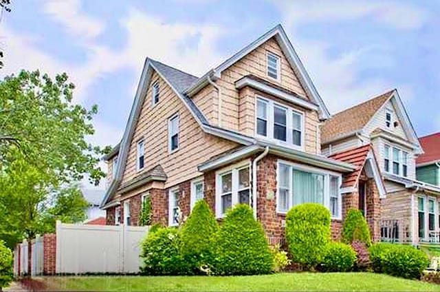 view of front of property featuring fence and a front lawn