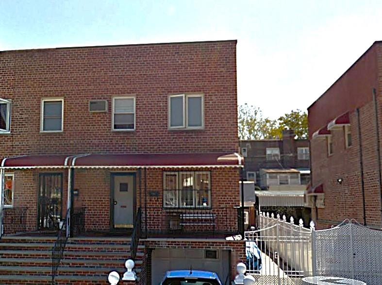 townhome / multi-family property with brick siding and a garage