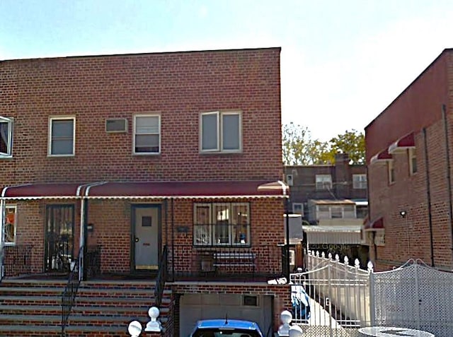townhome / multi-family property with brick siding and a garage