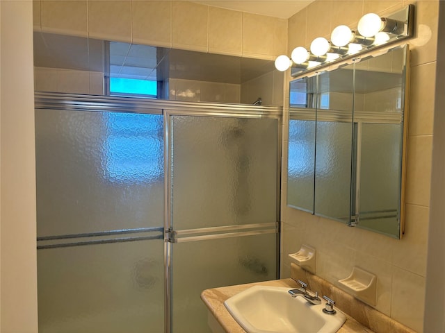 bathroom featuring a sink and a shower with shower door
