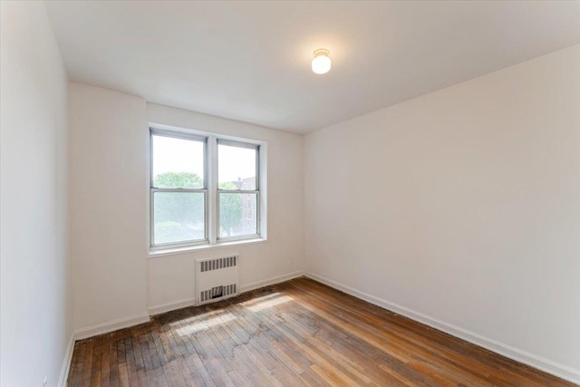 142-20 26th Ave Unit 5H, Flushing, NY 11354 - unfurnished room featuring radiator, hardwood / wood-style flooring, and baseboards