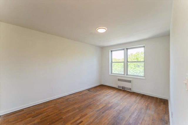 142-20 26th Ave Unit 5H, Flushing, NY 11354 - empty room with radiator, hardwood / wood-style floors, and baseboards