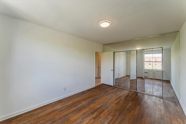 142-20 26th Ave Unit 5H, Flushing, NY 11354 - unfurnished bedroom with hardwood / wood-style floors, baseboards, and a closet