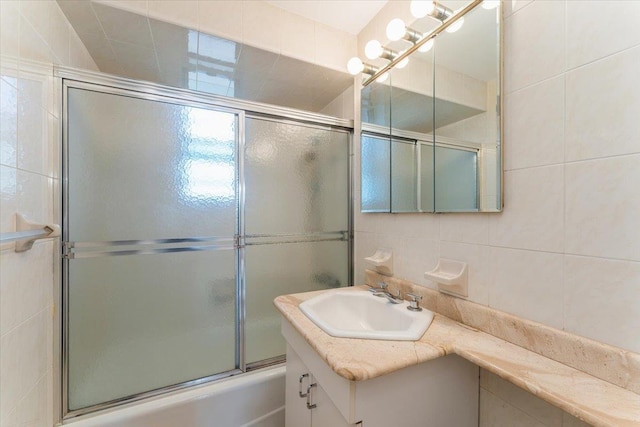 142-20 26th Ave Unit 5H, Flushing, NY 11354 - bathroom featuring tile walls, vanity, and enclosed tub / shower combo