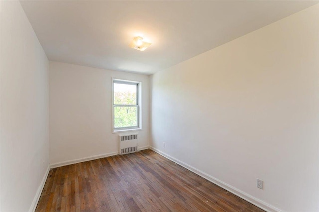 142-20 26th Ave Unit 5H, Flushing, NY 11354 - spare room featuring radiator heating unit, wood finished floors, and baseboards