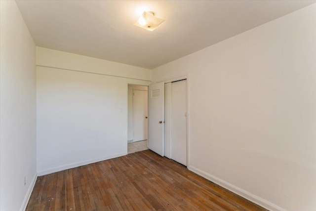 142-20 26th Ave Unit 5H, Flushing, NY 11354 - unfurnished bedroom featuring wood-type flooring, a closet, and baseboards