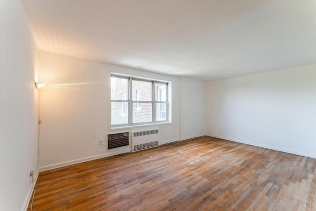 142-20 26th Ave Unit 5H, Flushing, NY 11354 - spare room with radiator heating unit, wood finished floors, and baseboards