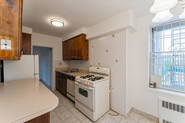 142-20 26th Ave Unit 5H, Flushing, NY 11354 - kitchen with white appliances, radiator, a sink, light countertops, and light tile patterned floors