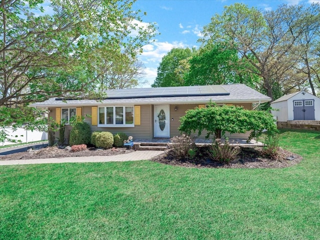 ranch-style house featuring roof mounted solar panels and a front lawn