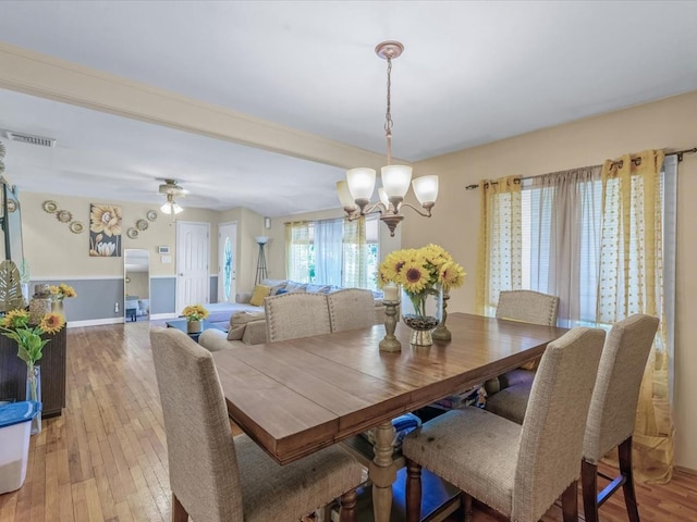 dining space with a chandelier, baseboards, light wood-type flooring, and visible vents