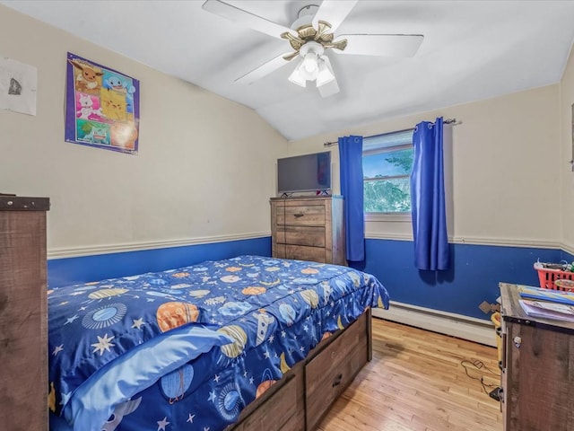 bedroom with wood finished floors, vaulted ceiling, a baseboard radiator, a ceiling fan, and baseboards