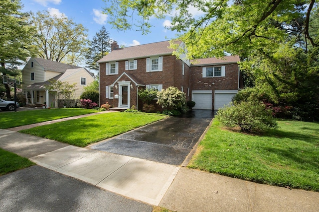 19 Donald St, East Williston, NY 11596 - colonial house featuring driveway, brick siding, an attached garage, and a chimney
