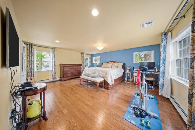 19 Donald St, East Williston, NY 11596 - bedroom featuring a baseboard radiator, wood finished floors, baseboards, and recessed lighting