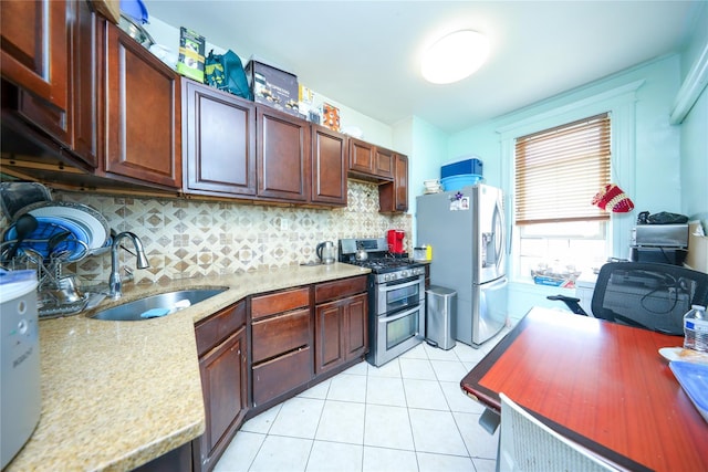 kitchen with stainless steel appliances, a sink, decorative backsplash, and light tile patterned flooring