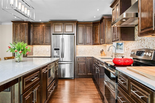 kitchen with a sink, stainless steel appliances, ventilation hood, dark brown cabinetry, and tasteful backsplash