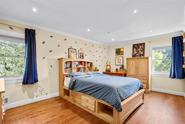 bedroom with crown molding, light wood-style flooring, and baseboards