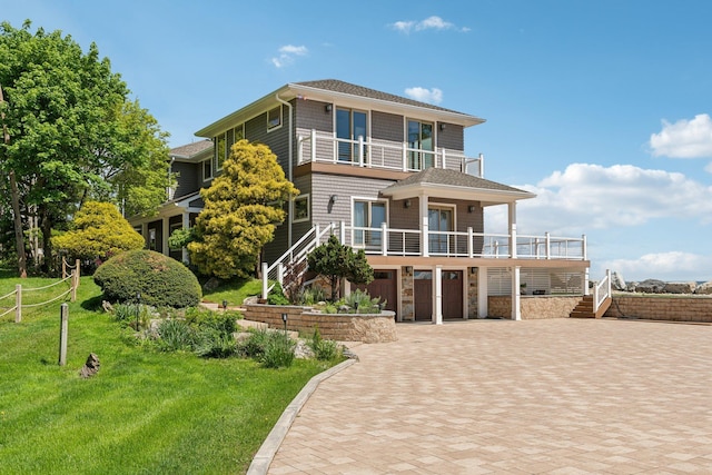 516 Asharoken Ave, Northport, NY 11768 - view of front of property featuring a balcony, stairway, a garage, decorative driveway, and a front yard