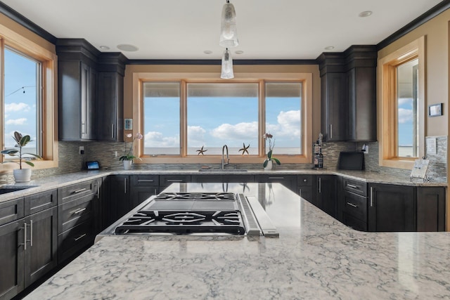 516 Asharoken Ave, Northport, NY 11768 - kitchen with stainless steel gas cooktop, light stone counters, a sink, decorative backsplash, and crown molding
