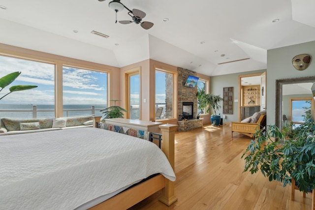 516 Asharoken Ave, Northport, NY 11768 - bedroom featuring a water view, multiple windows, a fireplace, light wood-type flooring, and lofted ceiling