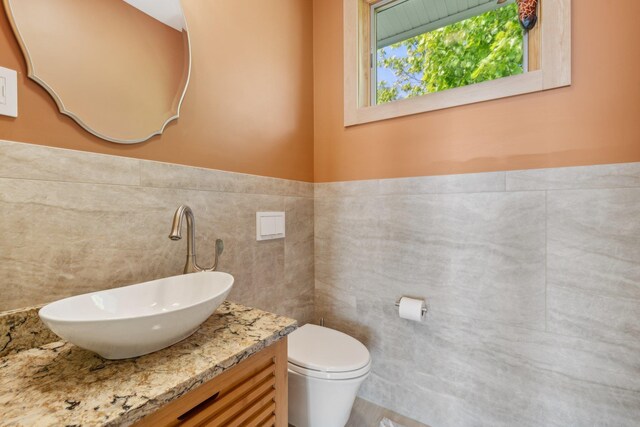 516 Asharoken Ave, Northport, NY 11768 - half bath with tile walls, toilet, vanity, and a wainscoted wall