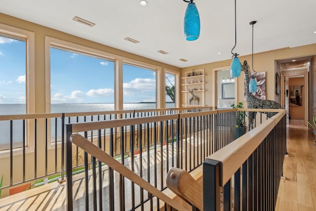 516 Asharoken Ave, Northport, NY 11768 - corridor featuring a water view, light wood-style flooring, and an upstairs landing