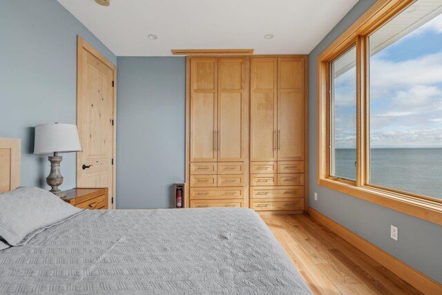 516 Asharoken Ave, Northport, NY 11768 - bedroom with light wood finished floors, baseboards, and a water view