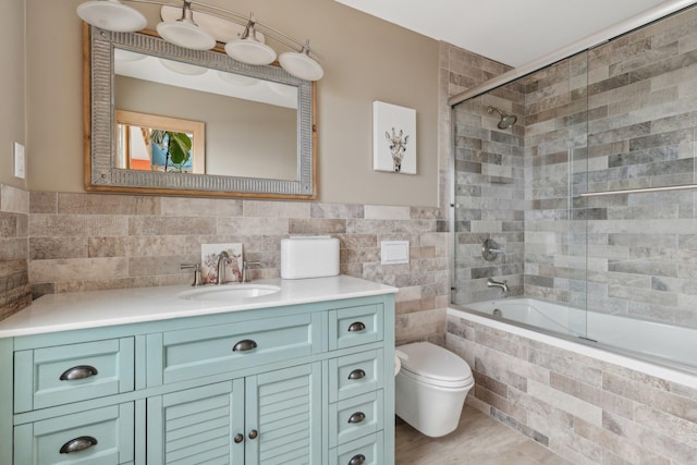 516 Asharoken Ave, Northport, NY 11768 - full bath with tile walls, tiled shower / bath combo, toilet, vanity, and wainscoting