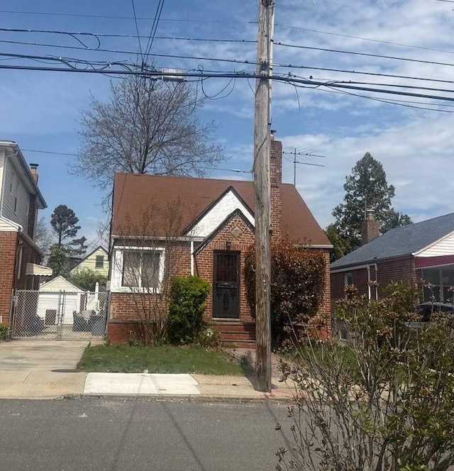 223-15 114th Rd, Cambria Heights, NY 11411 - bungalow with brick siding, fence, and a chimney