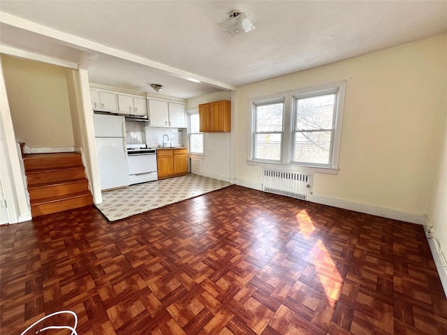 kitchen featuring tasteful backsplash, a sink, baseboards, radiator, and white appliances