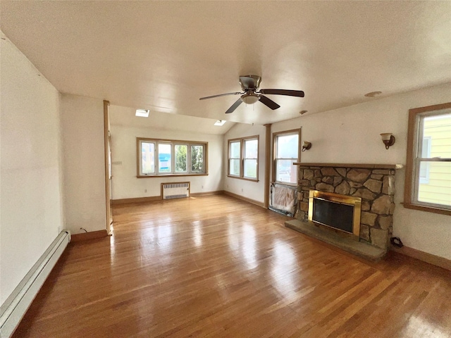 unfurnished living room featuring baseboard heating, a stone fireplace, radiator heating unit, and wood finished floors